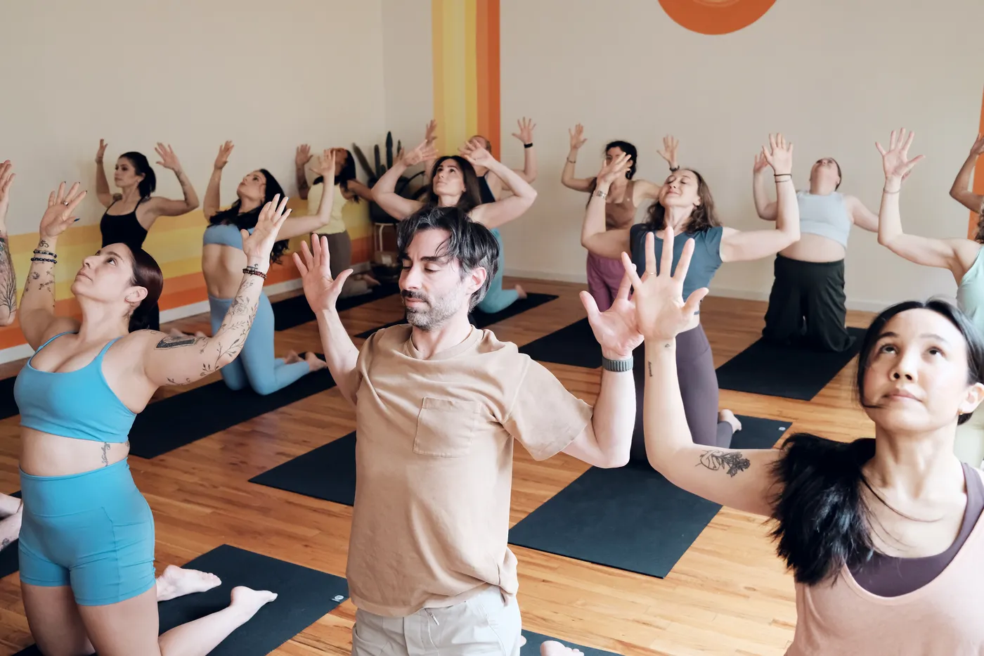 Students laughing with arms raised high during an energizing flow