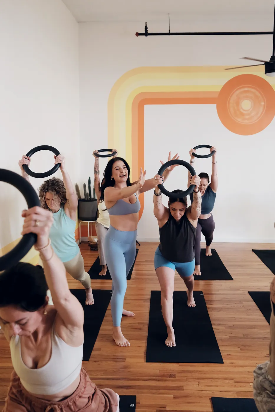 Students lunging with resistance rings raised overhead
