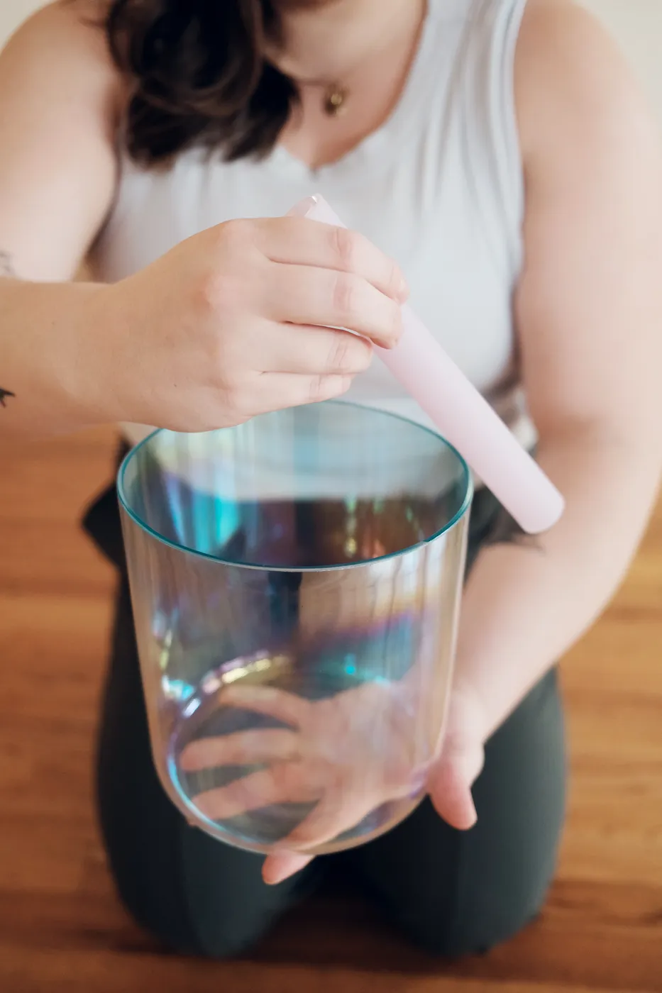 Hands holding a crystal singing bowl during a sound bath meditation